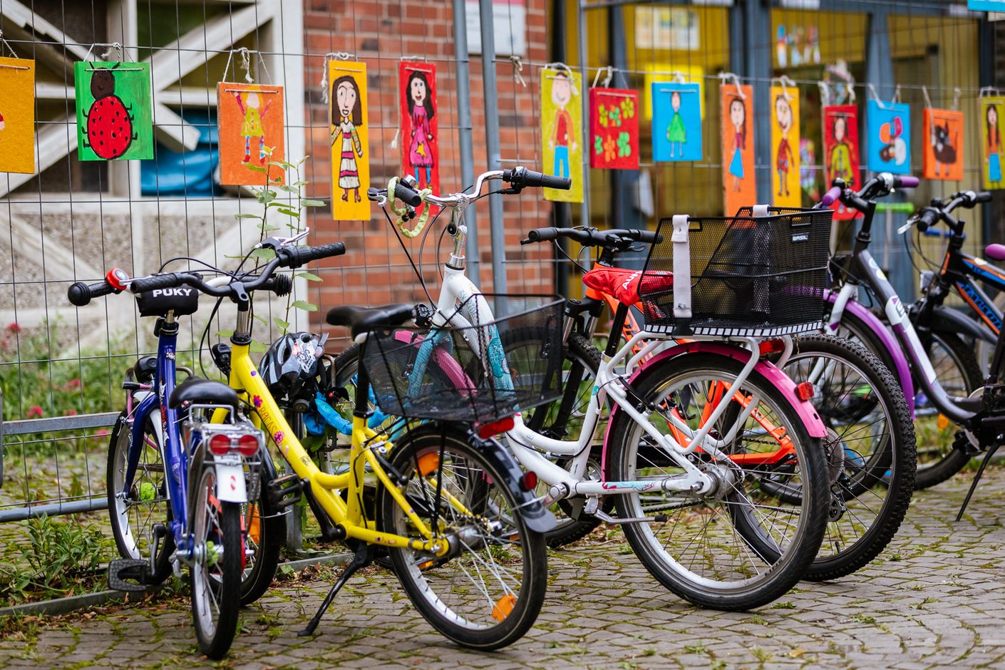 Eine Bildergalerie zeigt Erwachsene und Kinder, die mit dem Fahrrad zur Schule oder in der Freizeit unterwegs sind.